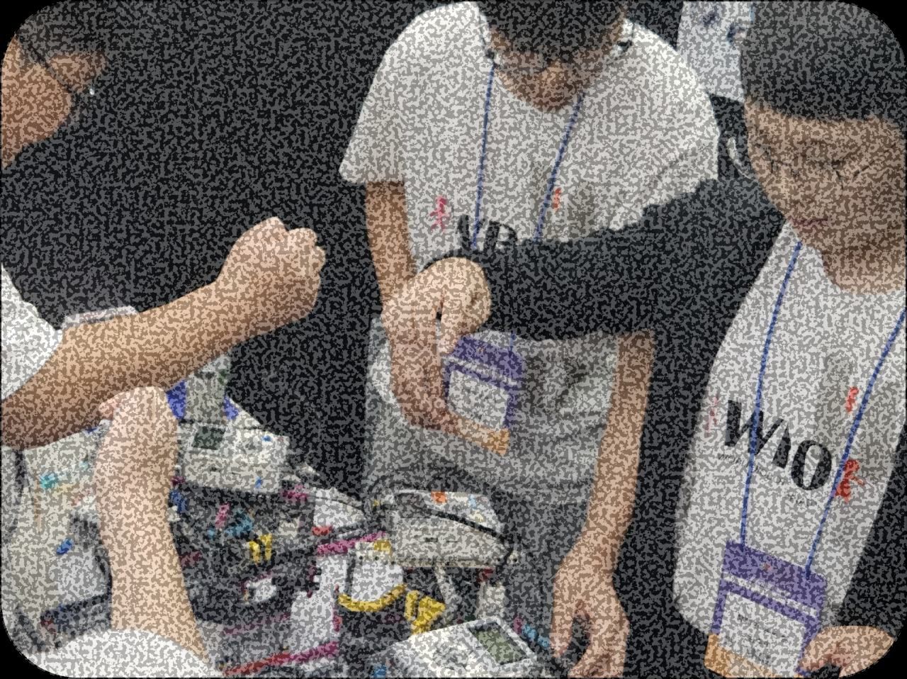 로봇을 함께 조정하는 학생들의 손